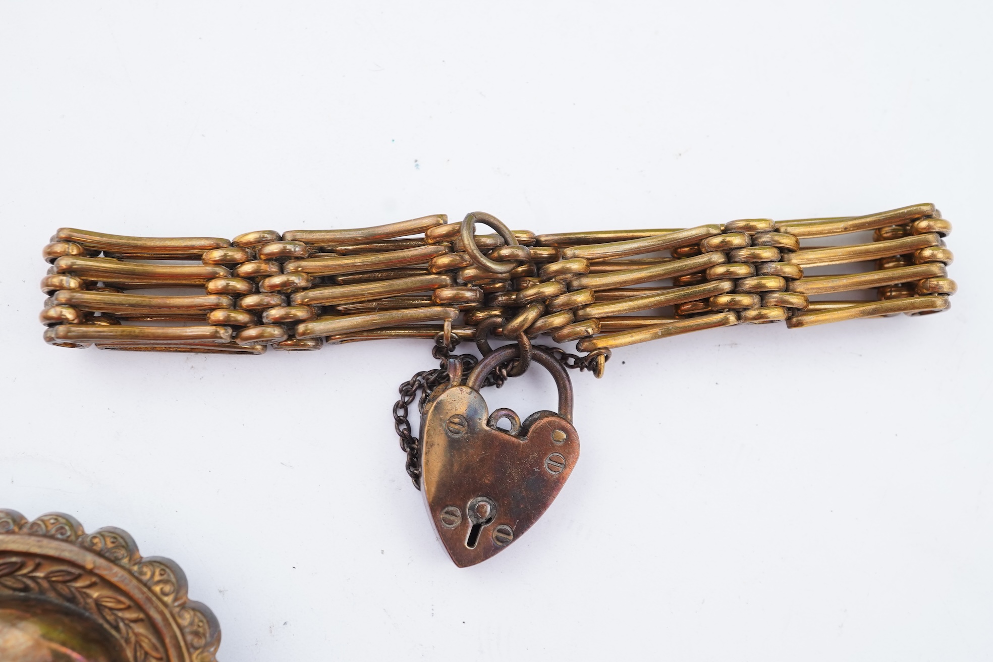 A group of gilt metal/pinchbeck jewels, 19th and early 20th century, comprising: a brooch of knotted design; two gate bracelets; a fancy link bracelet; an open-faced pocket watch; two oval panel brooches, and two watch c